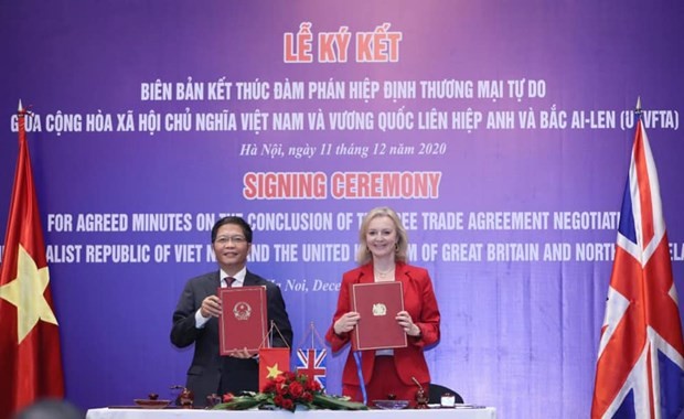 Minister of Industry and Trade Tran Tuan Anh and UK Secretary of State for International Trade Liz Truss sign the agreed minutes on the conclusion of negotiations over the UK-Vietnam Free Trade Agreement on December 11. (Photo: VNA)